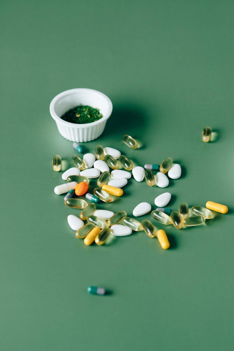 Nahrungsergänzungsmittel: Wann sie sinnvoll sind – und wann nicht 3 Assorted pills and herbal remedies displayed on green surface, emphasizing natural health concepts.