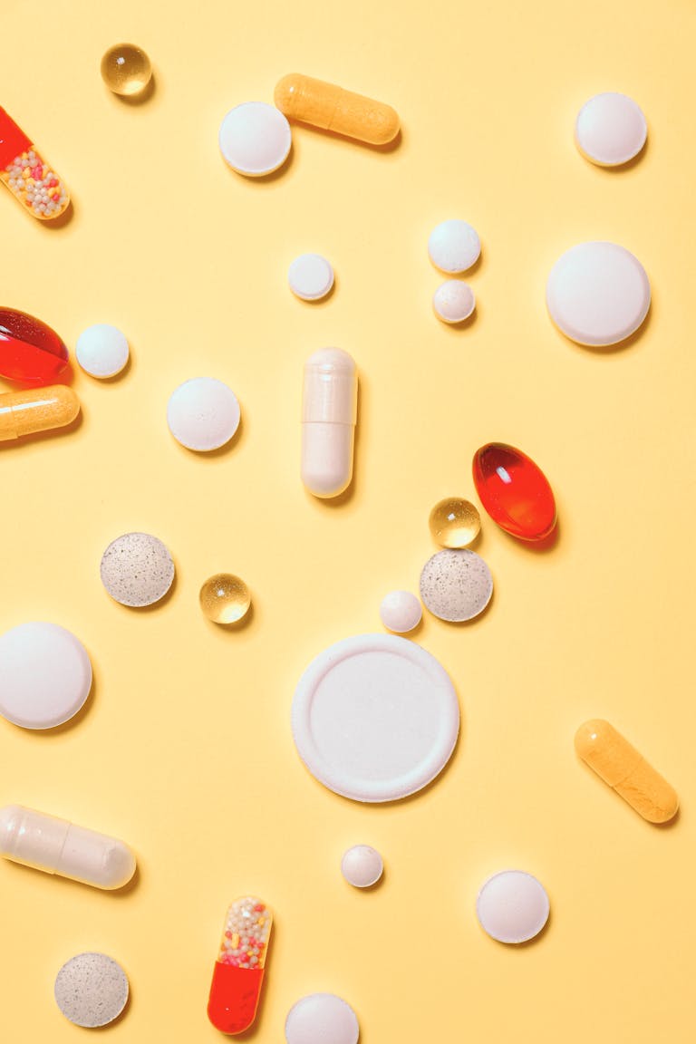 Omega-3-Fettsäuren: Warum sie unverzichtbar sind und wie du die richtige Quelle findest 1 Colorful assortment of pills and capsules on a vibrant yellow background.
